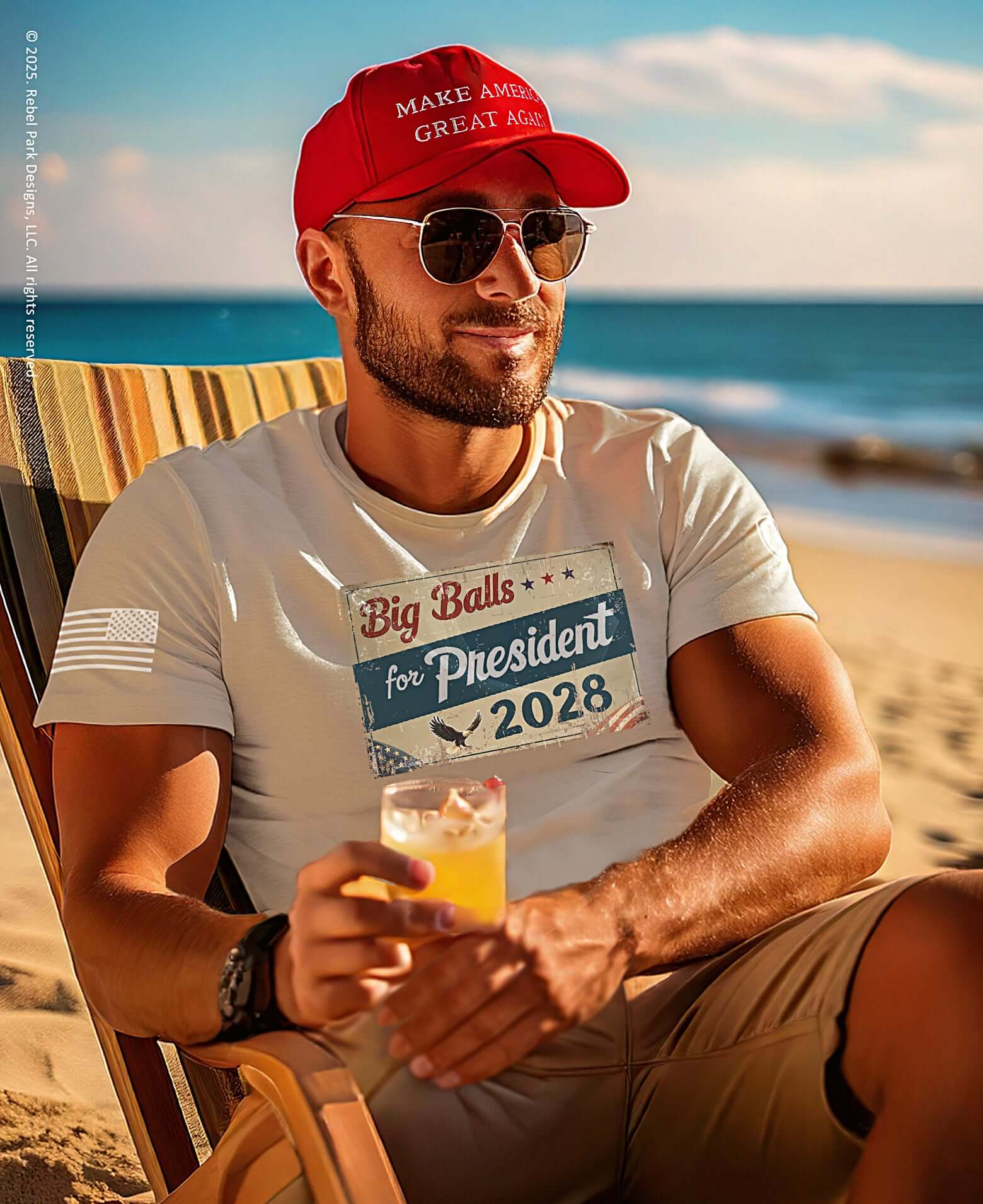 Man sitting on a beach holding a drink, wearing a 'Make America Great Again' cap and 'Big Balls for President 2028' shirt.