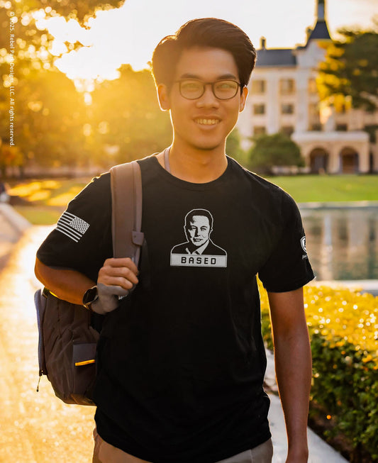 Person wearing a black t-shirt with a graphic design, standing outdoors with a blurred background