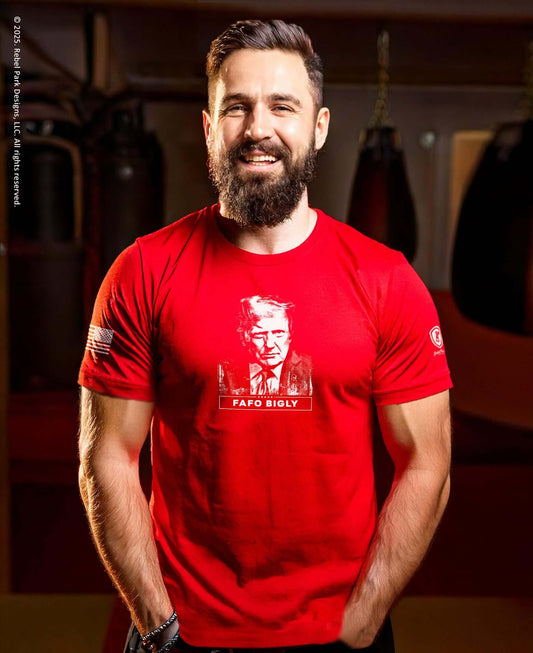 Man wearing a red t-shirt with a graphic design in an indoor setting