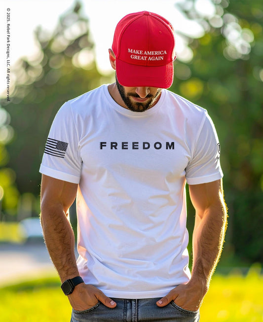 Man wearing a white t-shirt with 'FREEDOM' and a red cap with 'MAKE AMERICA GREAT AGAIN' text.