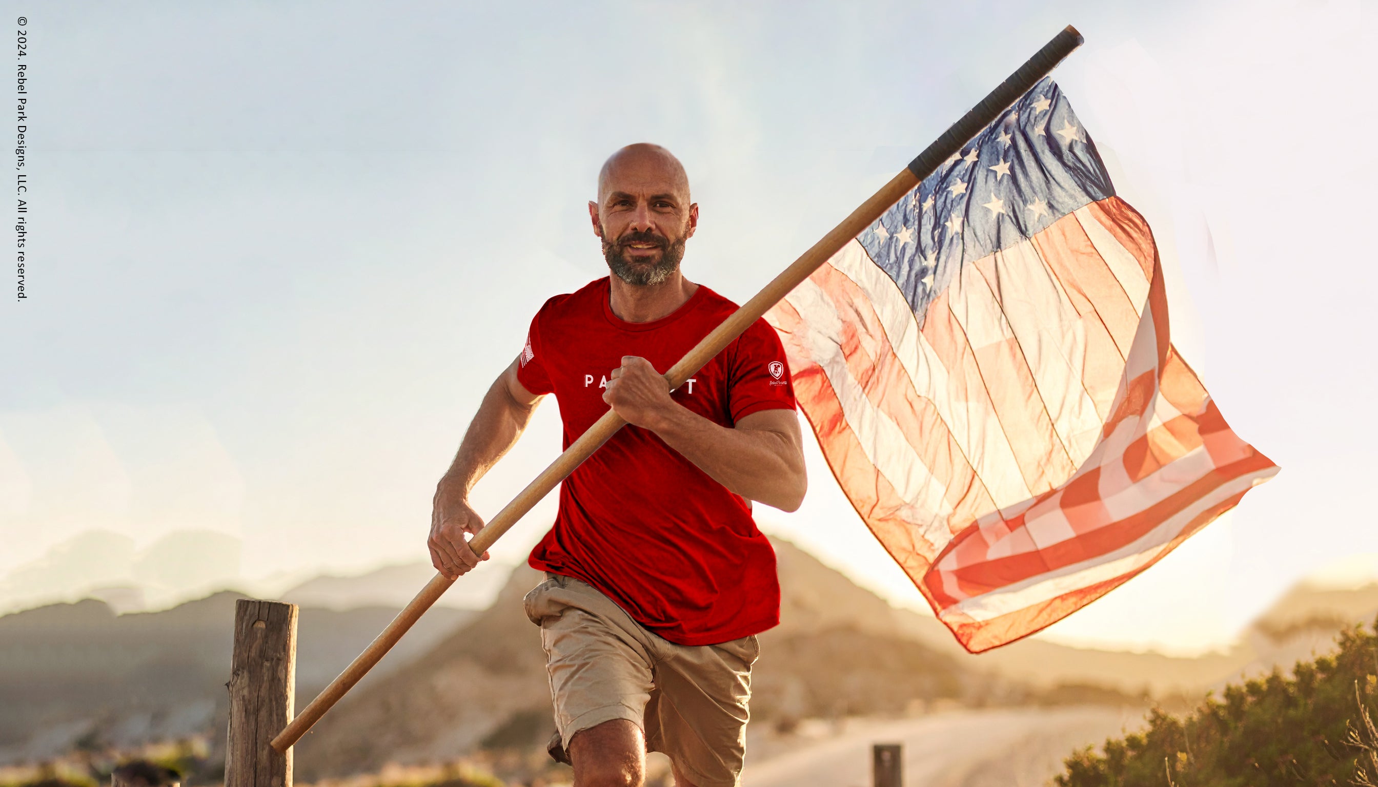 Man holding an American flag outdoors