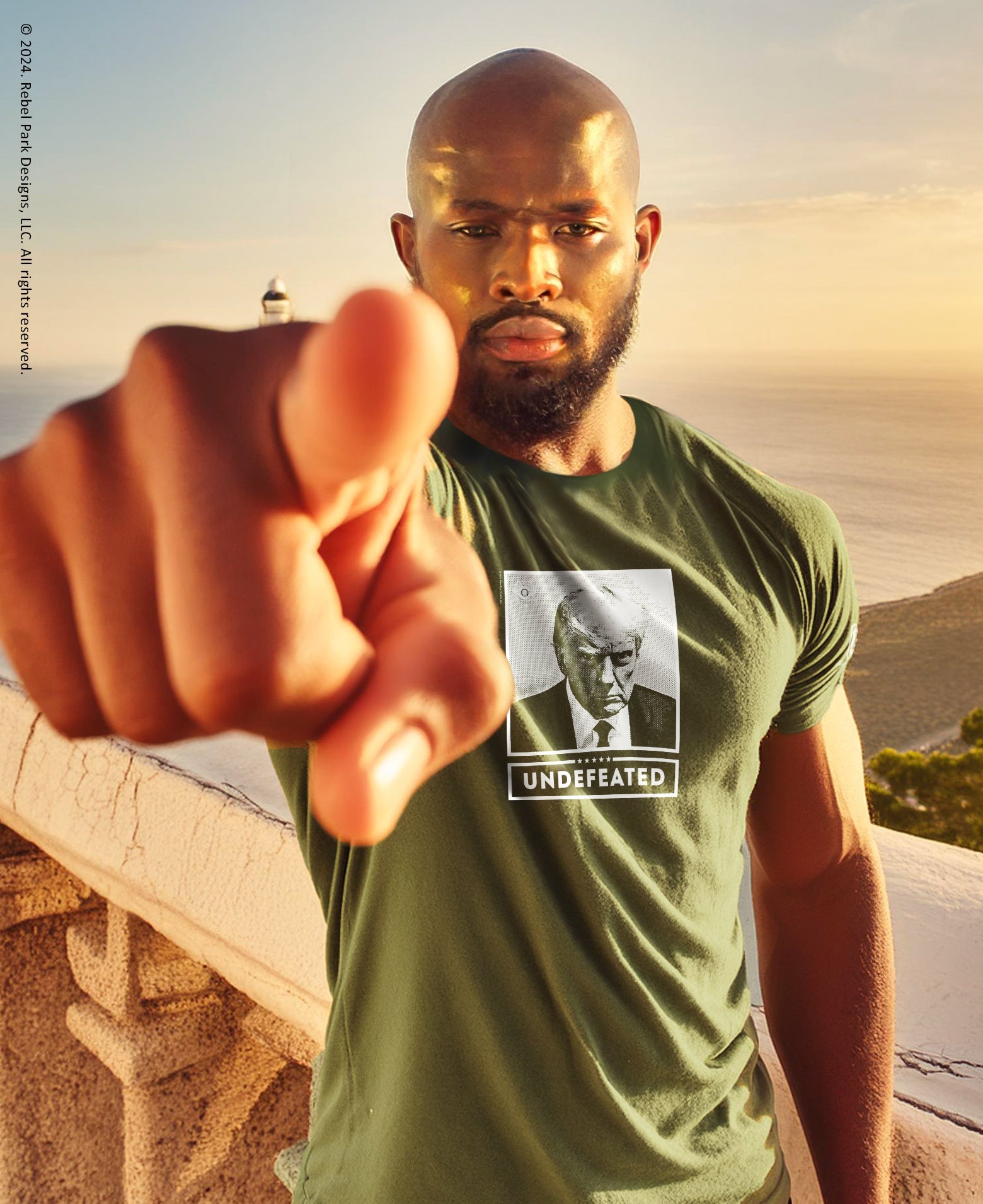 Man wearing a green t-shirt with a graphic of a man and 'Undefeated' text, standing outdoors.