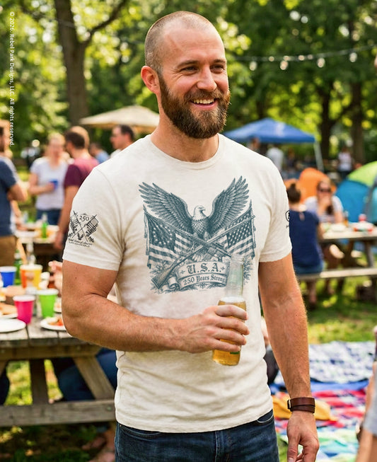 Man holding a beer at an outdoor gathering with people and tents in the background