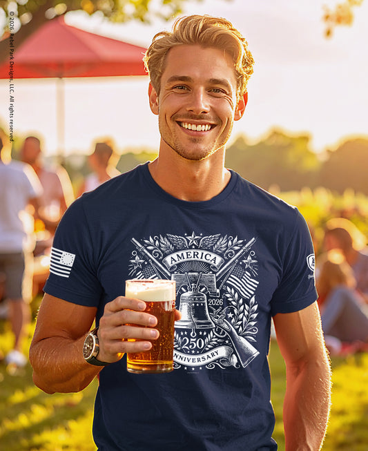 Man wearing a navy blue t-shirt with a graphic design, holding a beer in an outdoor setting.
