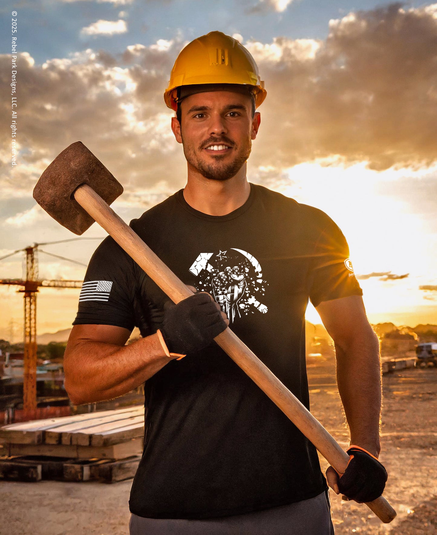 Man holding a large hammer with a construction site and sunset in the background