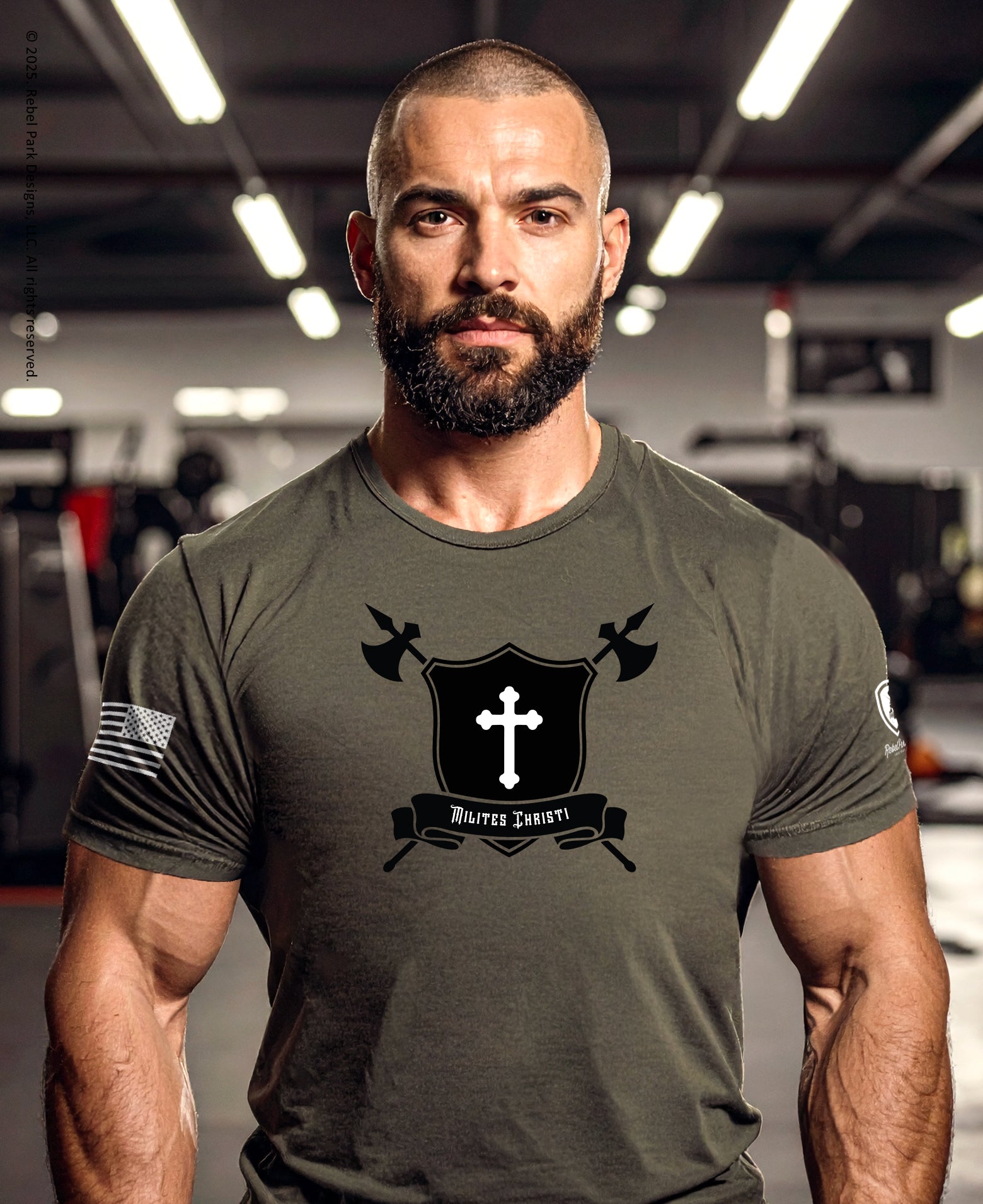 Man wearing a Christian Warrior Tee featuring a shield, battle axes, and a trinity cross emblem in a gym setting.