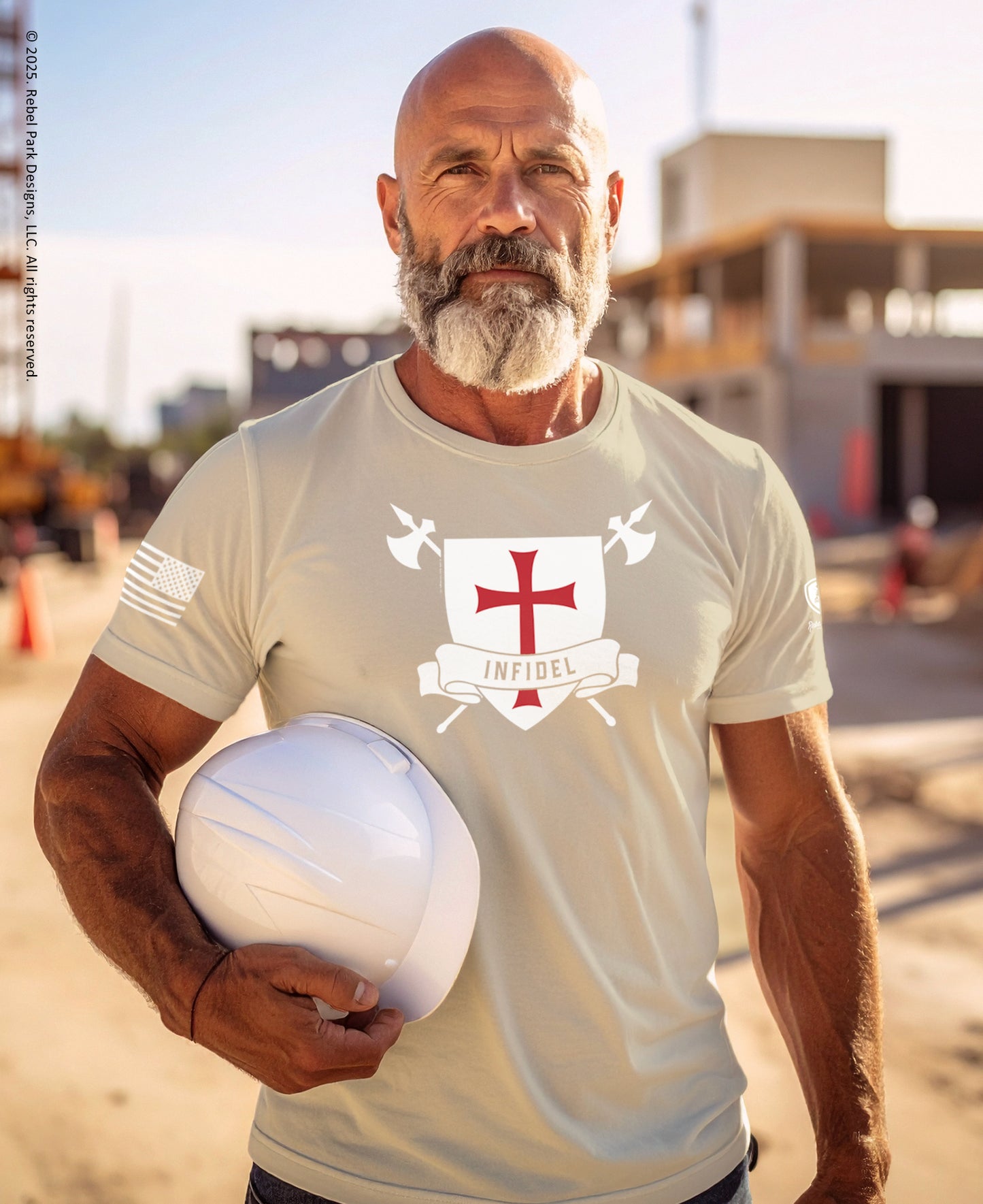 Man wearing a t-shirt with a logo, holding a helmet, outdoors.