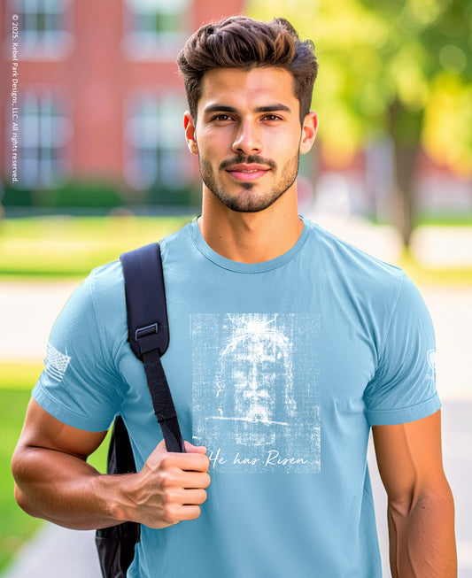 Man wearing a light blue t-shirt with a graphic design, standing outdoors.