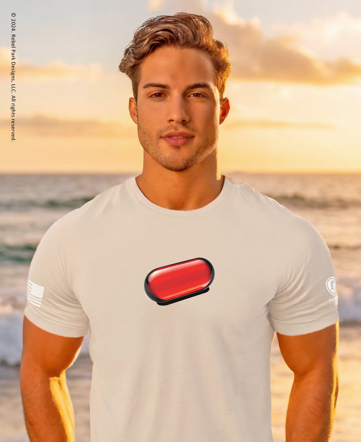 Man wearing a light gray t-shirt with a red logo on a beach at sunset