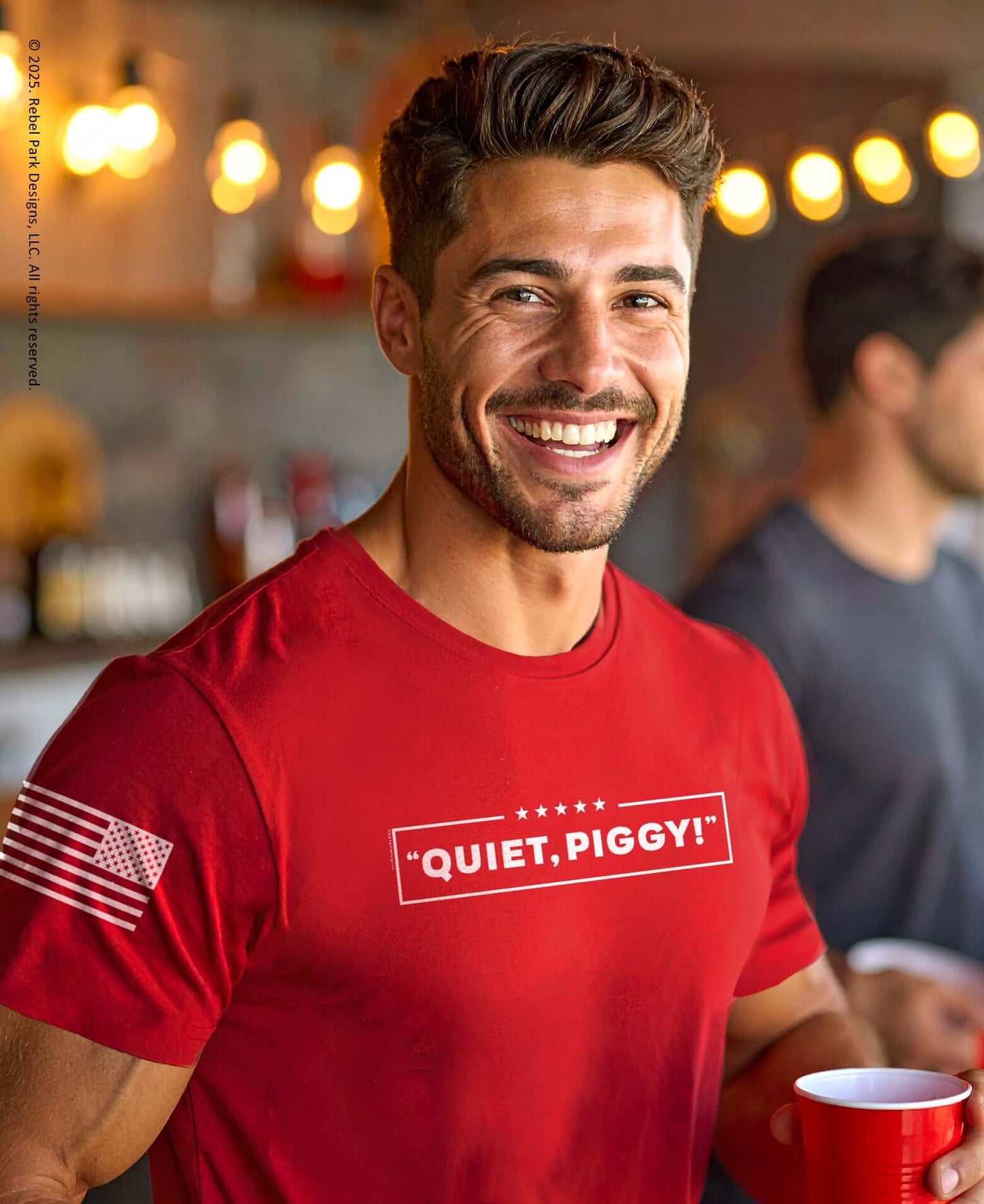 Quiet Piggy T-Shirt | Funny Trump Tee for Conservatives worn by a smiling man holding a red cup.