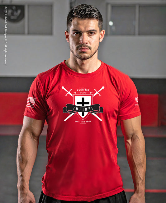 A man wearing a bright red athletic t-shirt with a black and white graphic on the chest that reads 'VERIFIED INFIDEL' with a cross and crossed swords, set against a gym background.